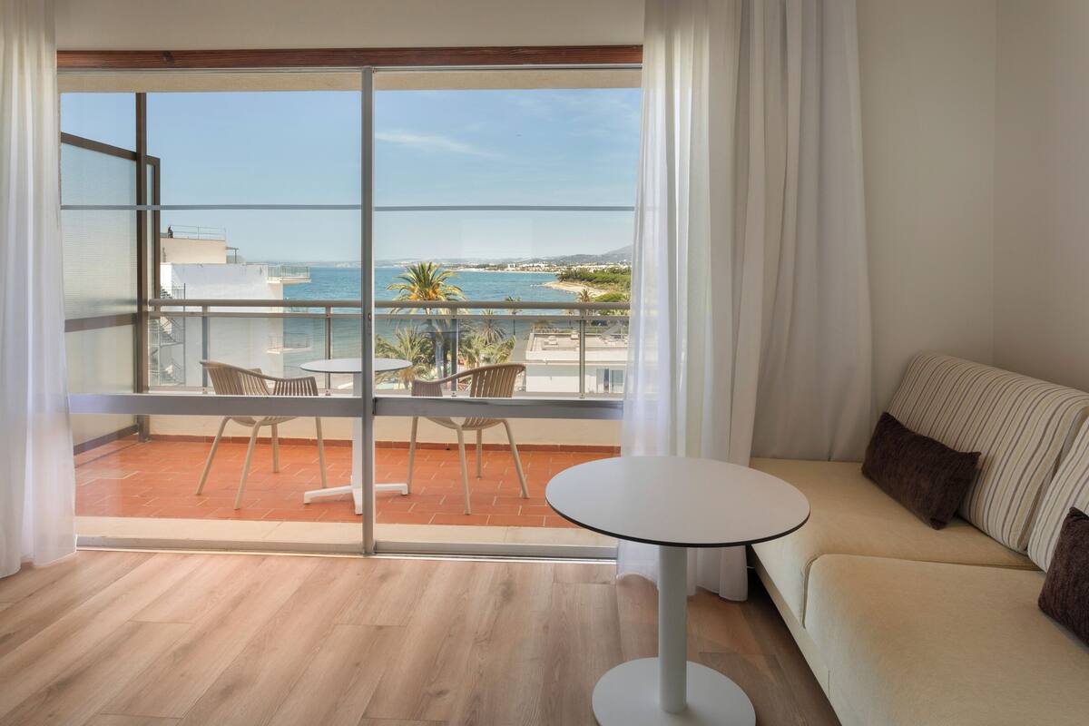 Un moderno salón con balcón y vistas a la costa.