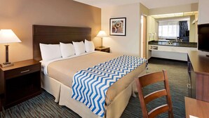 A hotel room with a bed, bedside tables, a desk, and a chair.