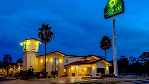 A hotel with a prominent sign, a central entrance, and a tower-like structure. - La Quinta Inn by Wyndham Lufkin (Lufkin)