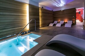 A modern spa with a heated pool, wooden walls, and lounge chairs. - Best Western Plus Hotel Genova (Turin)