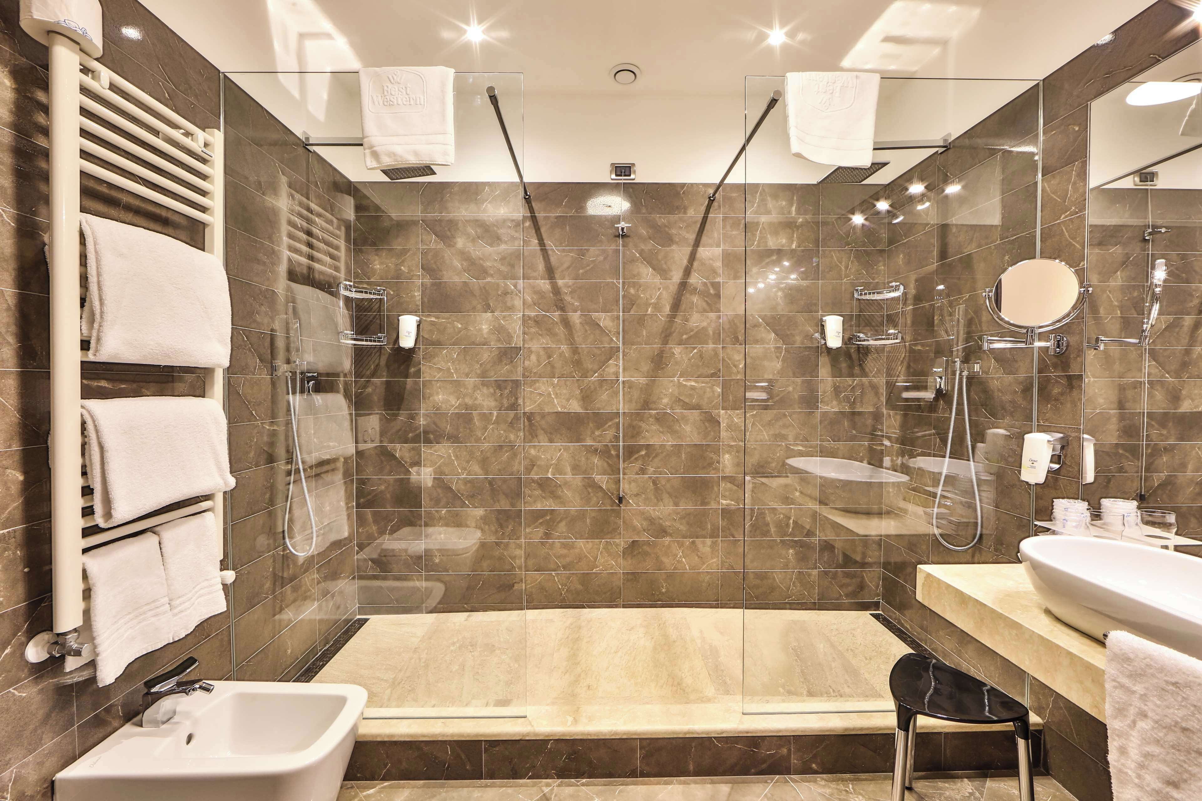 Un bagno moderno con uno specchio grande, un lavandino, una doccia e un porta asciugamani.