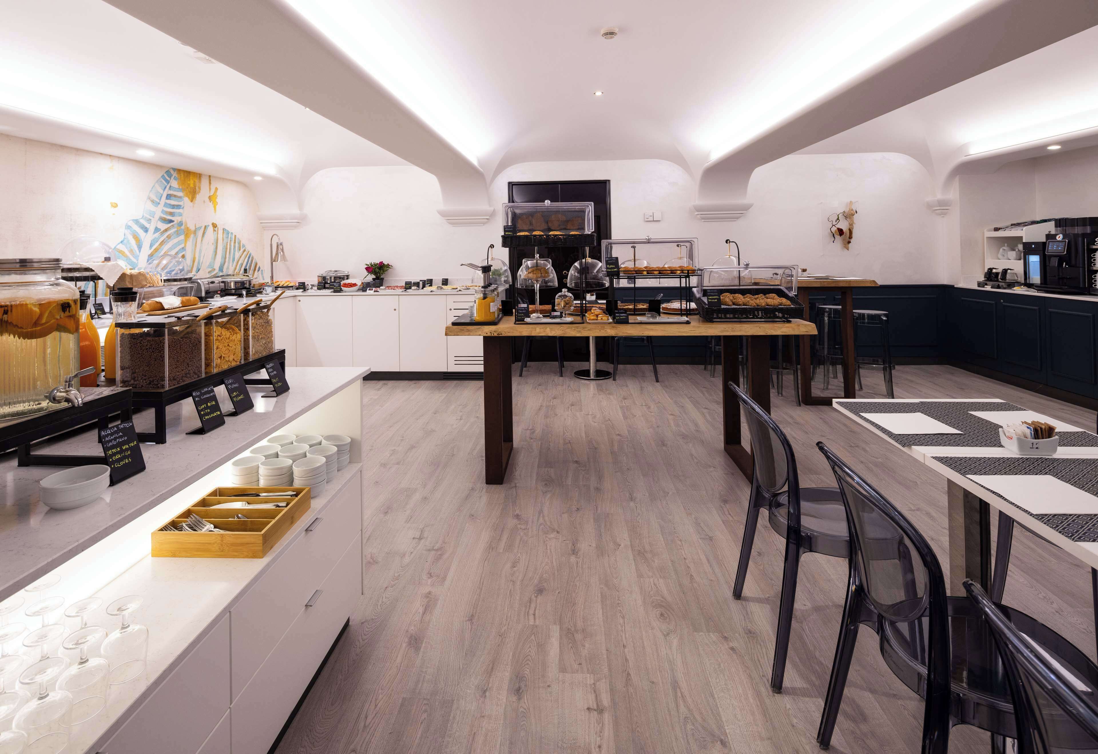 Un ricco buffet della colazione con diversi cibi e un angolo caffè.