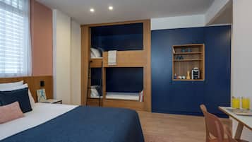 Un dormitorio con una cama litera, un escritorio y un armario.