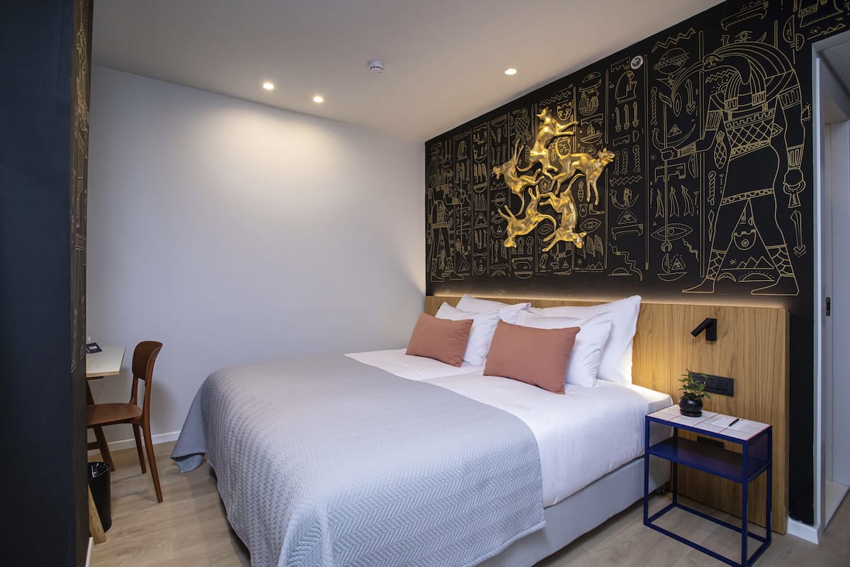 Une chambre à coucher moderne avec un grand lit, un bureau et une chaise.