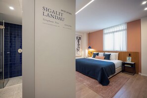 Une chambre d’hôtel avec un lit, une table de chevet, une lampe et une vue sur l’extérieur.
