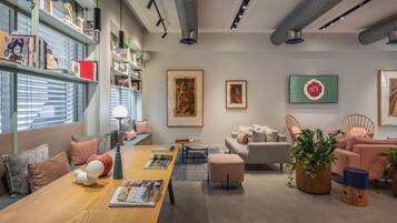 Un interior moderno con una mesa de madera, estanterías, un sofá y obras de arte.