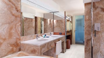 A modern bathroom with two sinks, a large mirror, and a shower area.