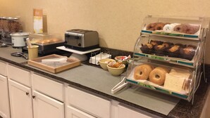 A breakfast buffet with various food items, a toaster, and a coffee station.