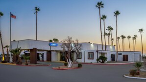 A hotel with a 'Lobby' sign, surrounded by palm trees, and a flag.