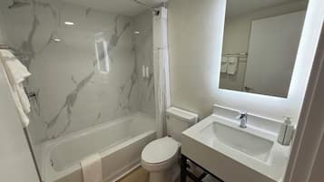 Tina con regadera, secadora de cabello, toallas