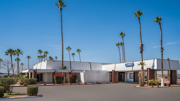 A building with a 'Lobby' sign, surrounded by palm trees and a clear sky.