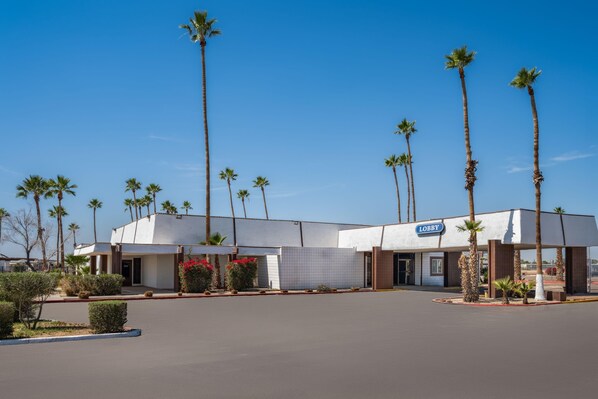 A building with a 'Lobby' sign, surrounded by palm trees and a clear sky. - Travelodge by Wyndham Imperial/El Centro (Imperial)