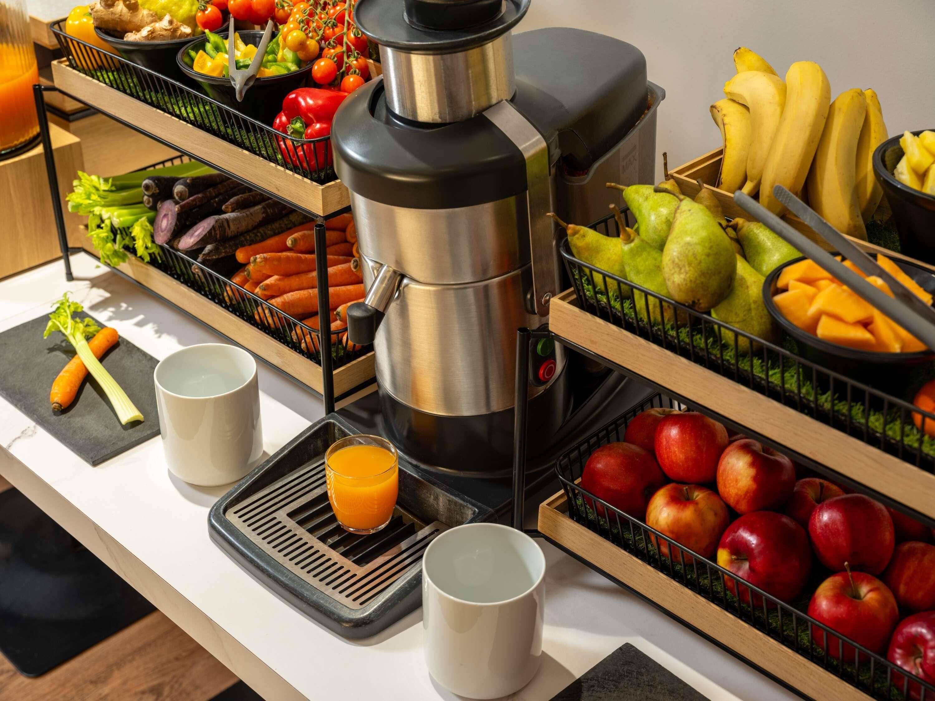 A breakfast buffet with various fruits, vegetables, and a coffee maker.