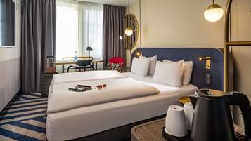 Ein Hotelzimmer mit einem großen Bett, einem Schreibtisch mit Stuhl, einem Fernseher und Blick ins Freie.