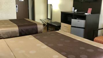 Une chambre d’hôtel avec deux lits, un bureau avec un ordinateur, une télévision et une chaise.