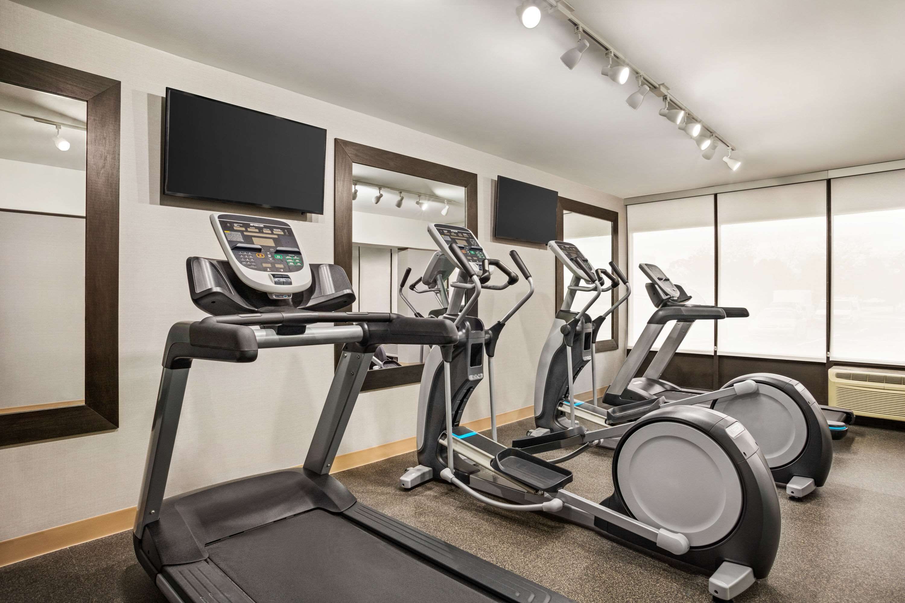 A gym with treadmills, ellipticals, and a stationary bike.