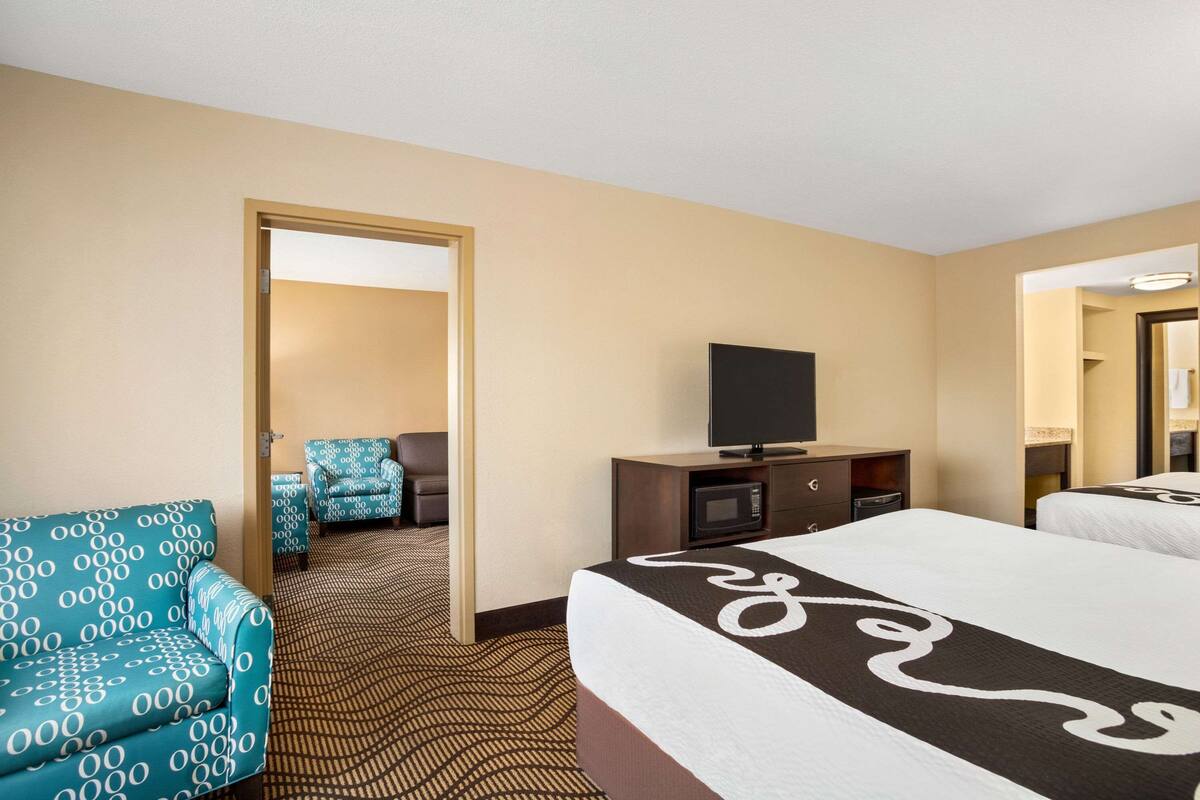 Een hotelkamer met een groot bed, een televisie, een bank en een bureau.