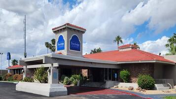A Travelodge hotel with a red-tiled roof, a stone facade, and a covered entrance.