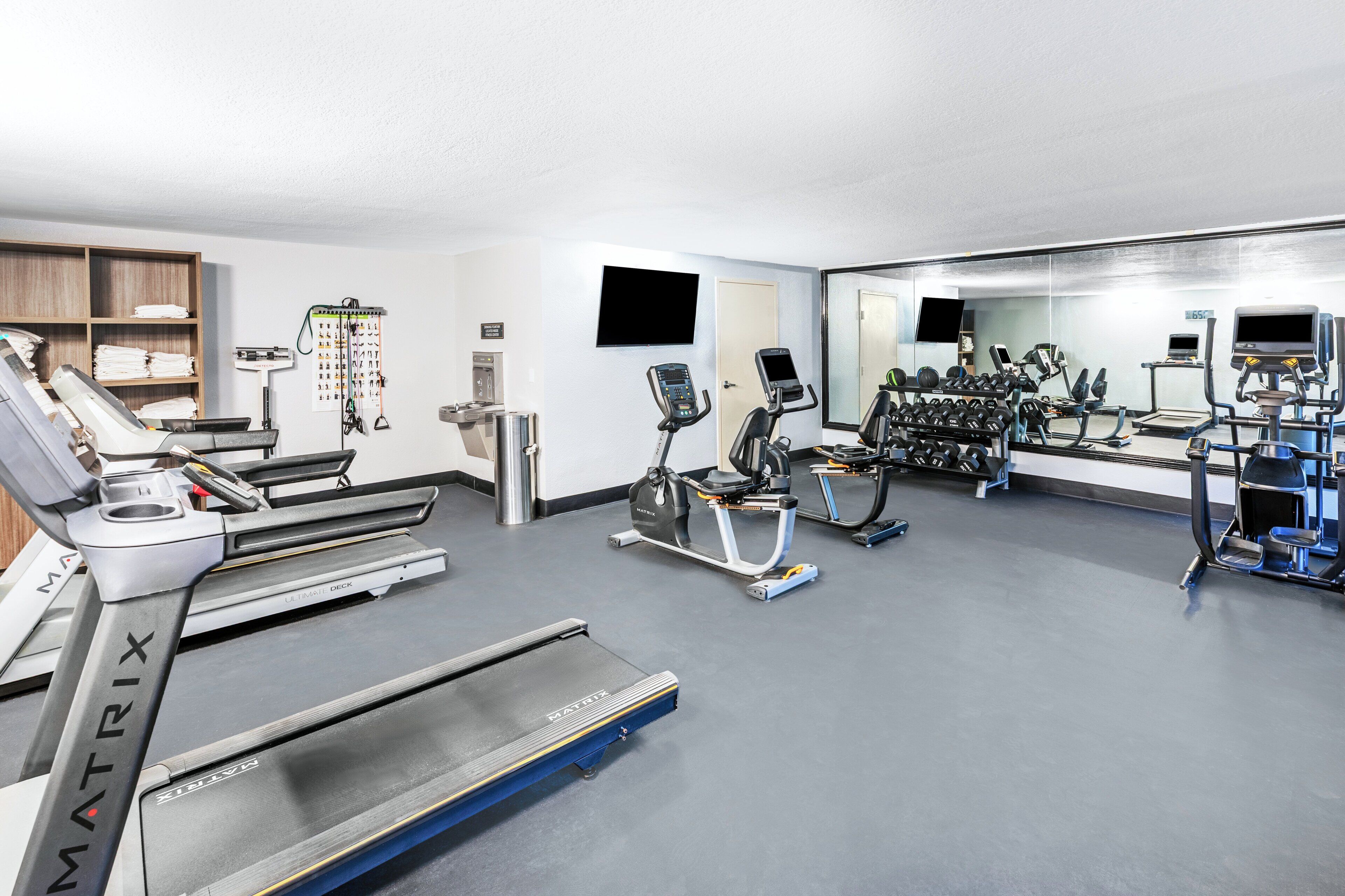 A gym with treadmills, stationary bikes, and weight machines.