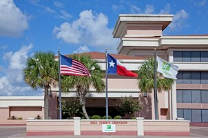 Un edificio con un letrero que dice '2929 JIMMY JOHNSON' y banderas de los Estados Unidos y de Texas.