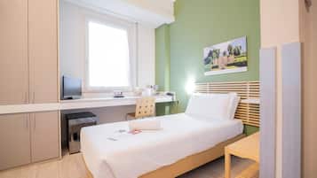 Ein Schlafzimmer mit Bett, Schreibtisch, Stuhl und Fenster.