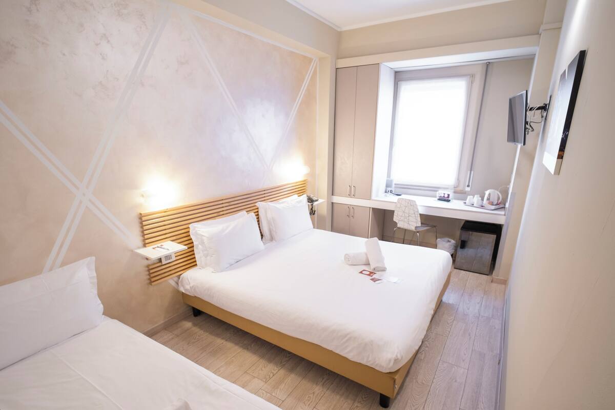 Une chambre d’hôtel avec un grand lit, un bureau et une fenêtre.