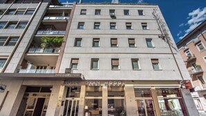 A hotel with a modern facade, multiple balconies, and a ground-level restaurant named "M**BUN." - Best Quality Hotel Gran Mogol (Turin)