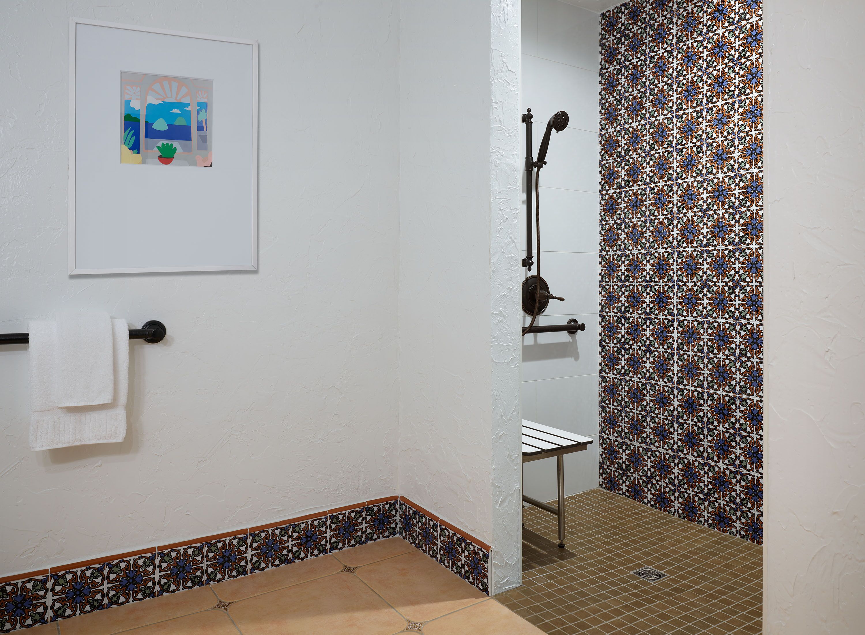 A bathroom with a shower, a towel rack, and a framed picture on the wall.