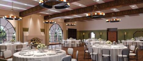 Une salle de banquet avec des tables rondes dressées pour le repas, de grandes fenêtres et un plafond haut avec des poutres apparentes.