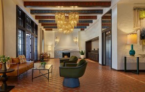 A spacious lobby with a fireplace, comfortable seating, and a large chandelier. - Mar Monte Hotel, in The Unbound Collection by Hyatt (Santa Barbara)