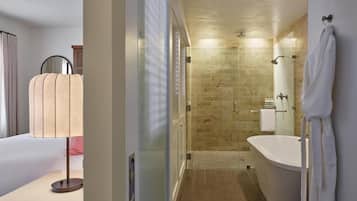A hotel bathroom with a shower, a bathtub, a toilet, and a mirror.