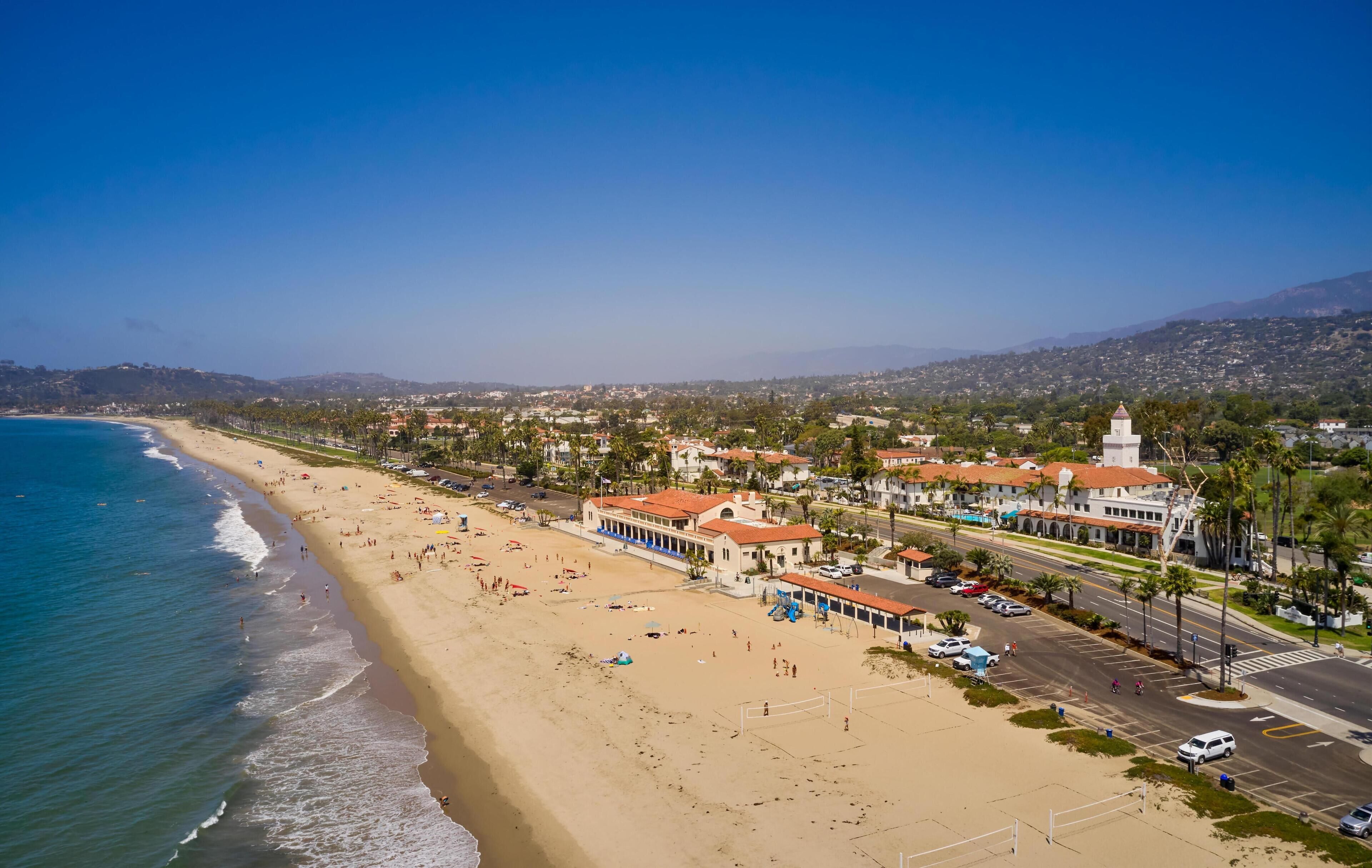 A coastal town with a beach, buildings, and a road.