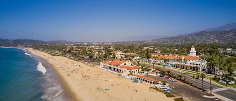A coastal town with a beach, buildings, and a road.