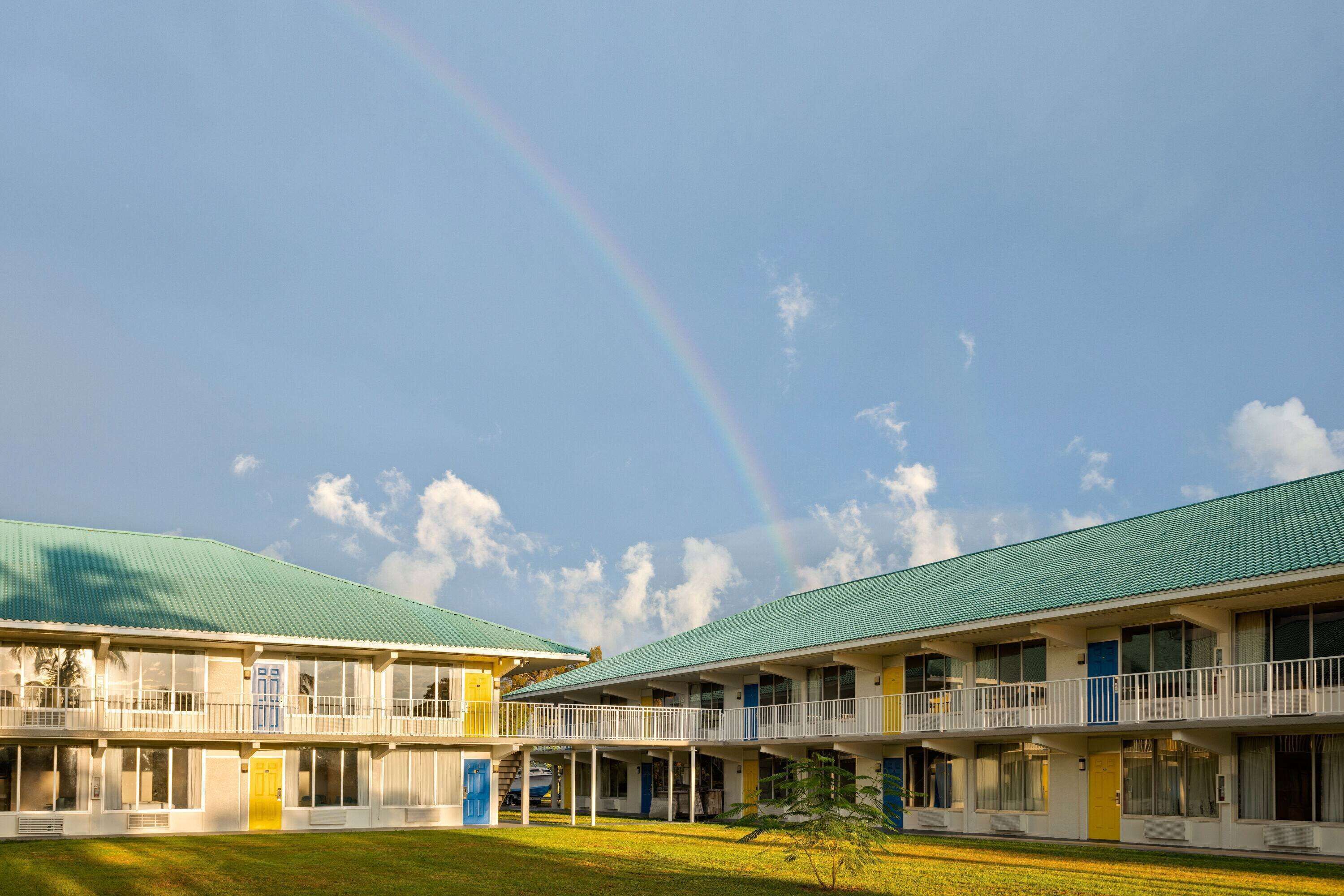 A motel with a green roof and multiple balconies.