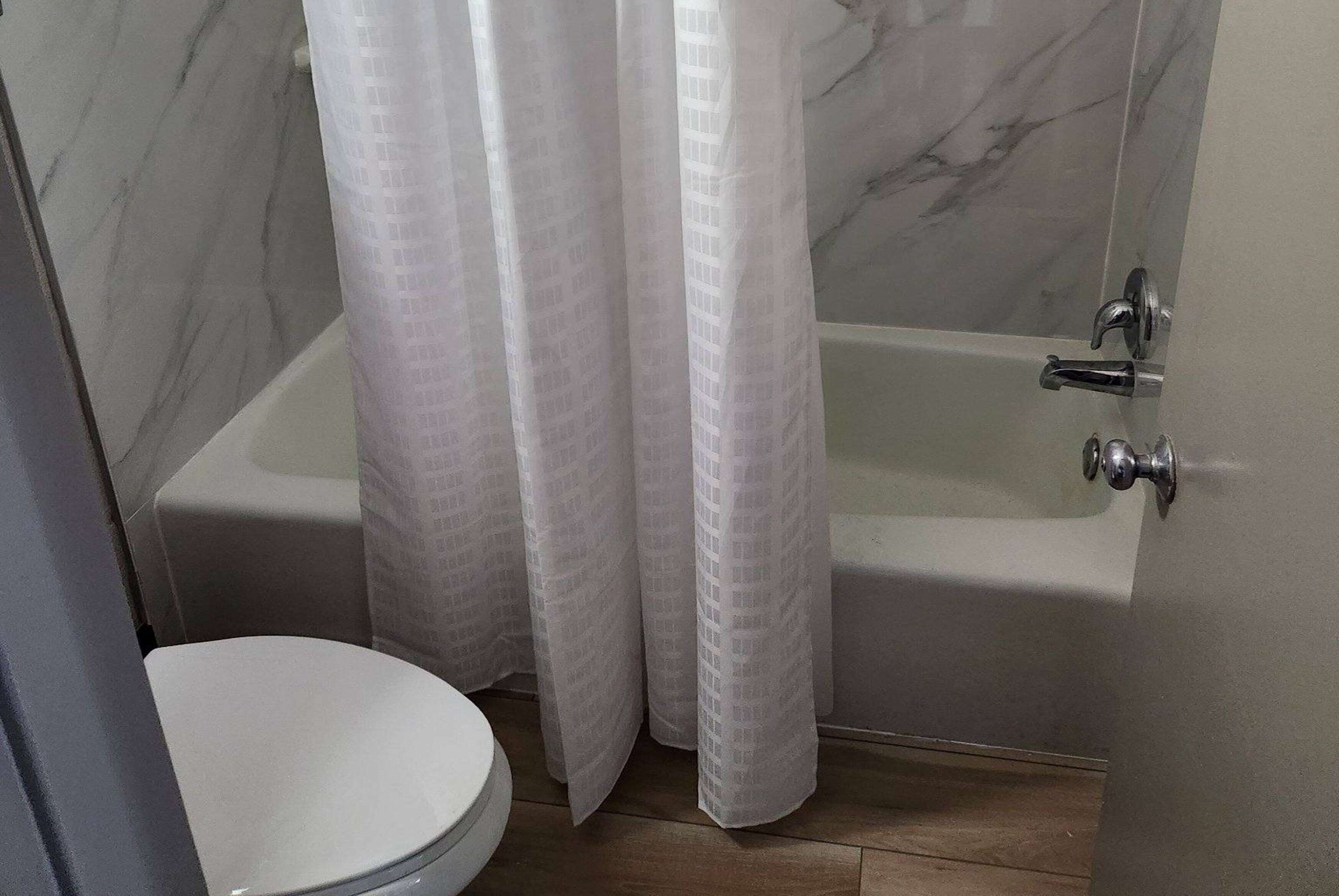 Un bagno con vasca, WC e pareti in marmo.