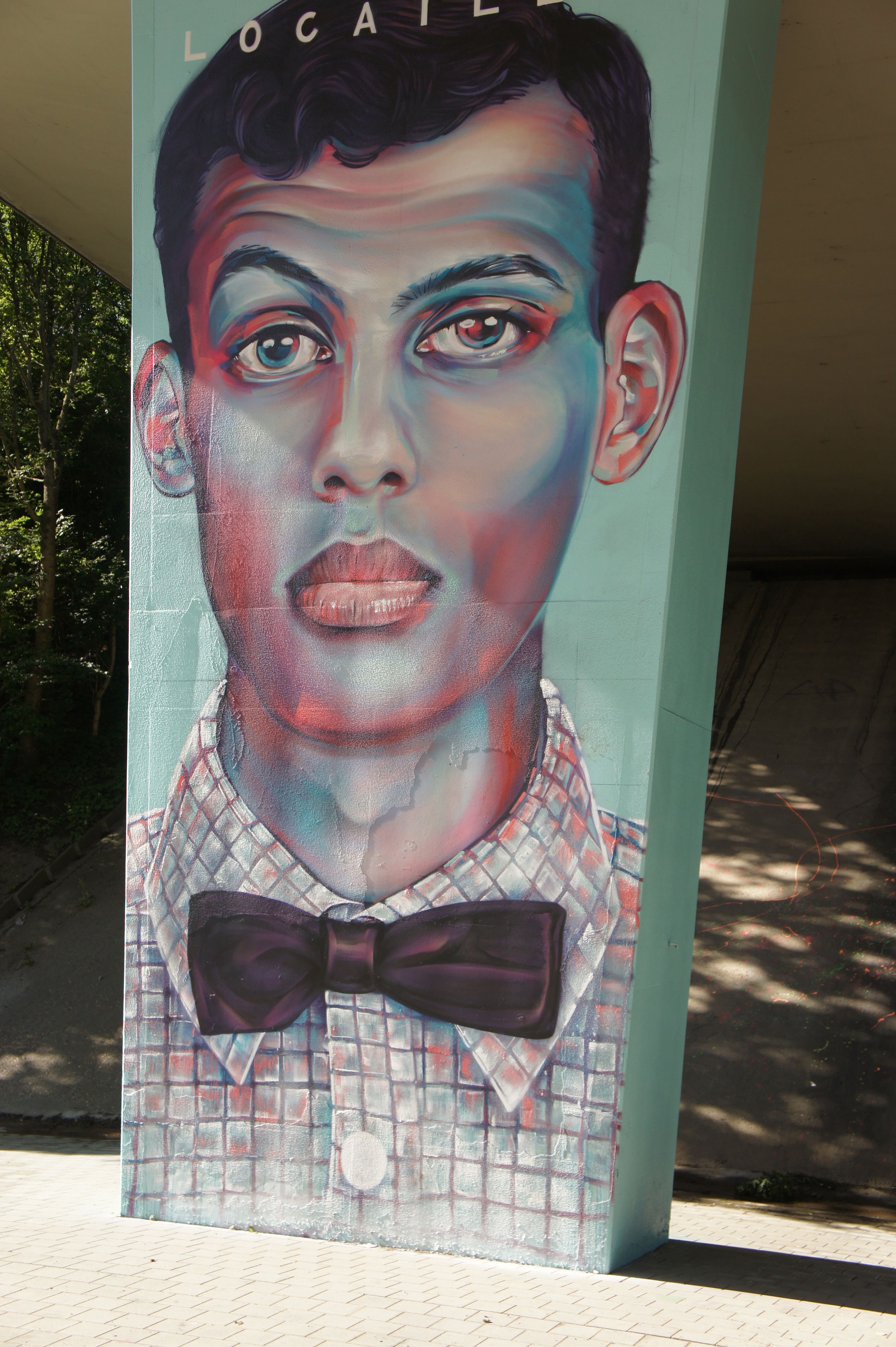 Une fresque représentant un homme portant un nœud papillon, peinte sur un mur.