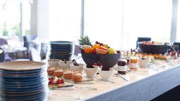 Une table de buffet avec divers plats et ustensiles.