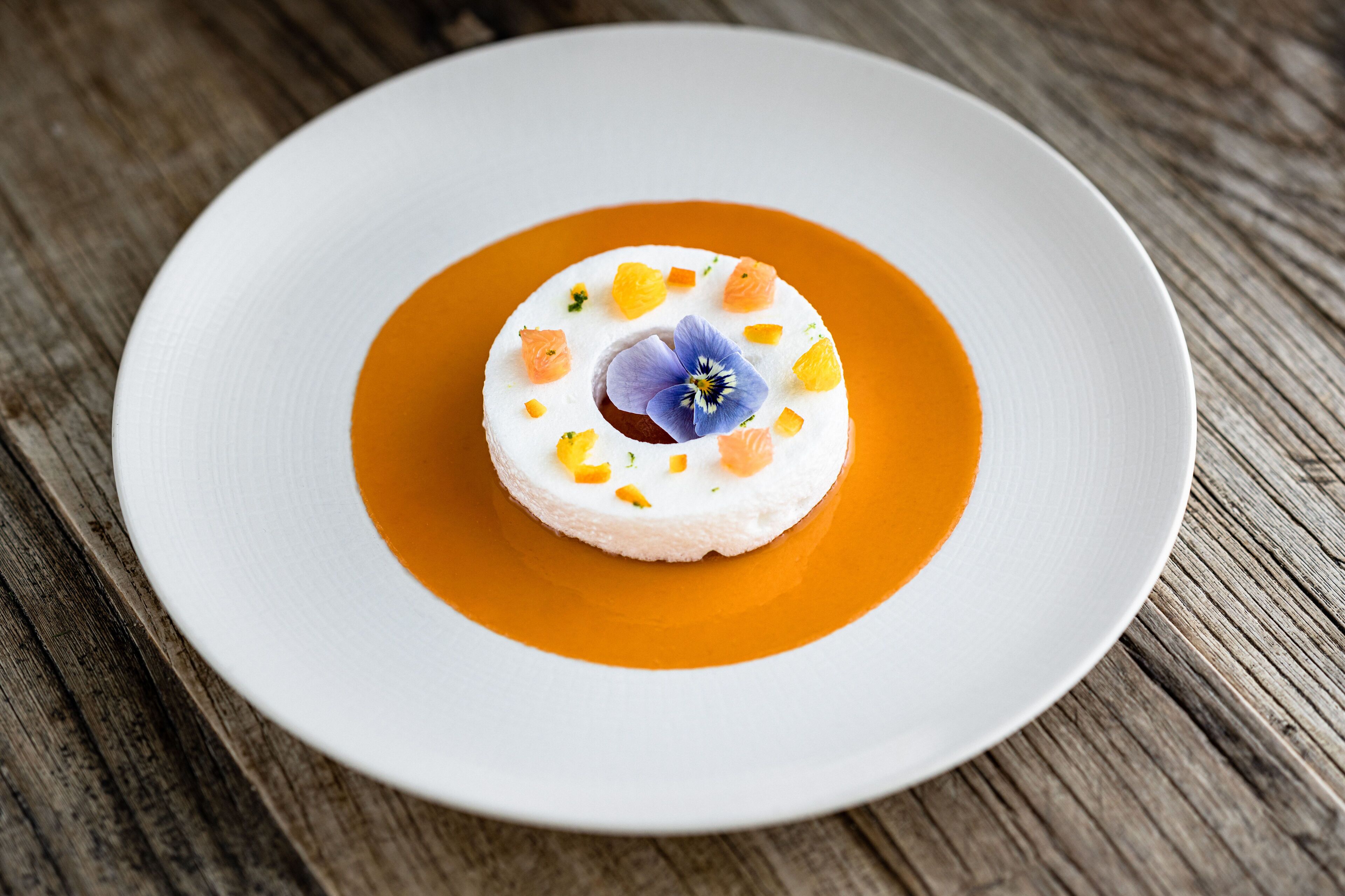 A dessert on a white plate with a wooden table background.