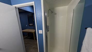 A bathroom with a shower, a toilet, and a sink.
