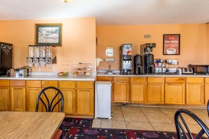 Une cuisine avec des meubles en bois, une machine à café et un réfrigérateur.