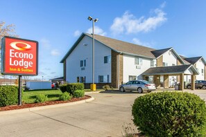 Un Econo Lodge à deux étages, doté d’un parking, d’un petit bâtiment attenant à la structure principale et surplombant un ciel dégagé.