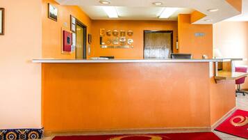 Un comptoir d’accueil à l’Econo Lodge, avec un tapis rouge et une enseigne au-dessus.