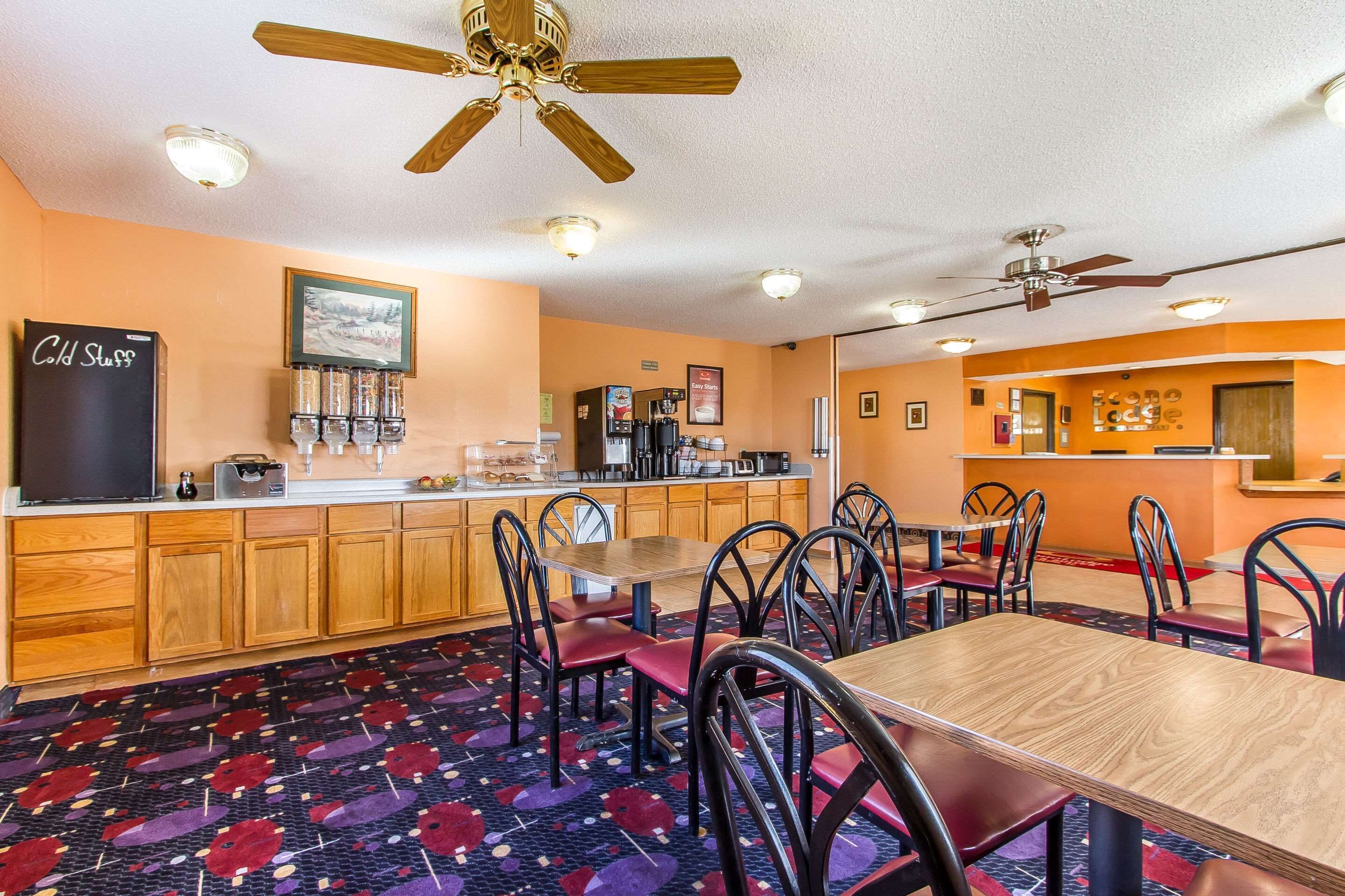 A restaurant with wooden cabinets, a counter, and a ceiling fan.