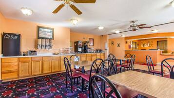 A restaurant with wooden cabinets, a counter, and a ceiling fan.
