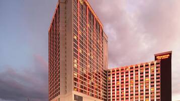 A hotel with a modern design, featuring a prominent corner building with a flat roof and a large number of windows.