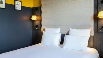 A hotel room with a large bed, two bedside lamps, and a headboard.