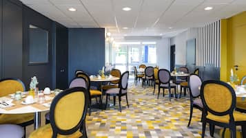 Un restaurante con varias mesas y sillas, suelo a cuadros y vistas al exterior.