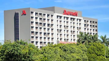 A Marriott hotel building with a modern facade, multiple balconies, and a prominent red logo.