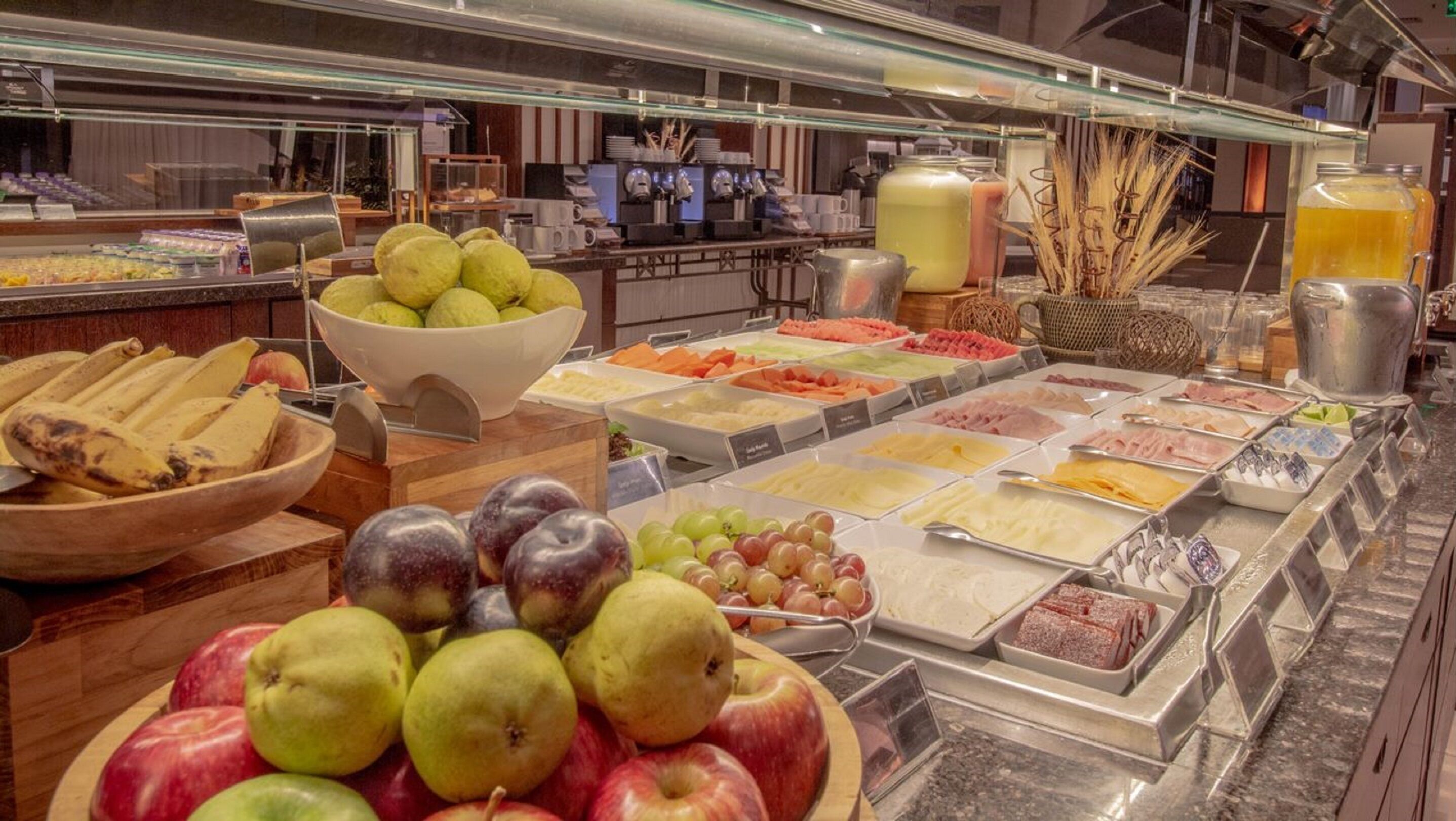 A buffet with various fruits, cheeses, and meats.