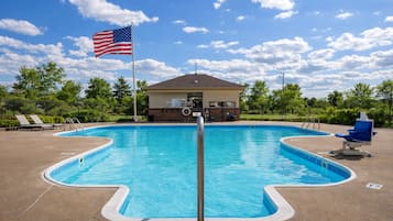 Una piscina al aire libre de temporada, sillones reclinables de piscina